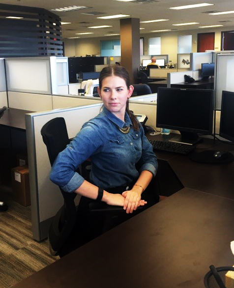 A woman stretches at her desk