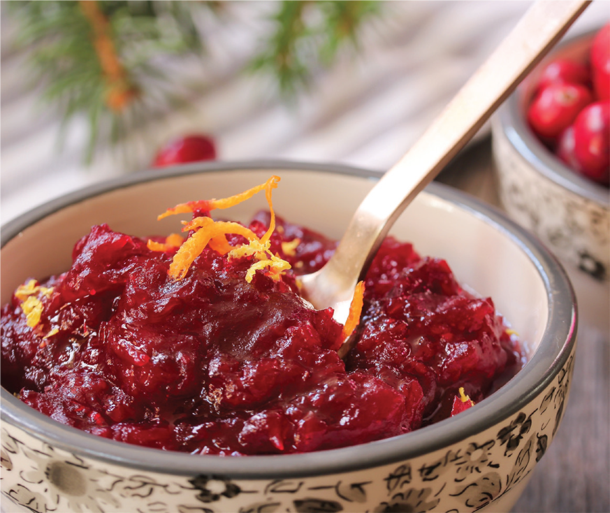 A bowl of healthy cranberry sauce topped with orange